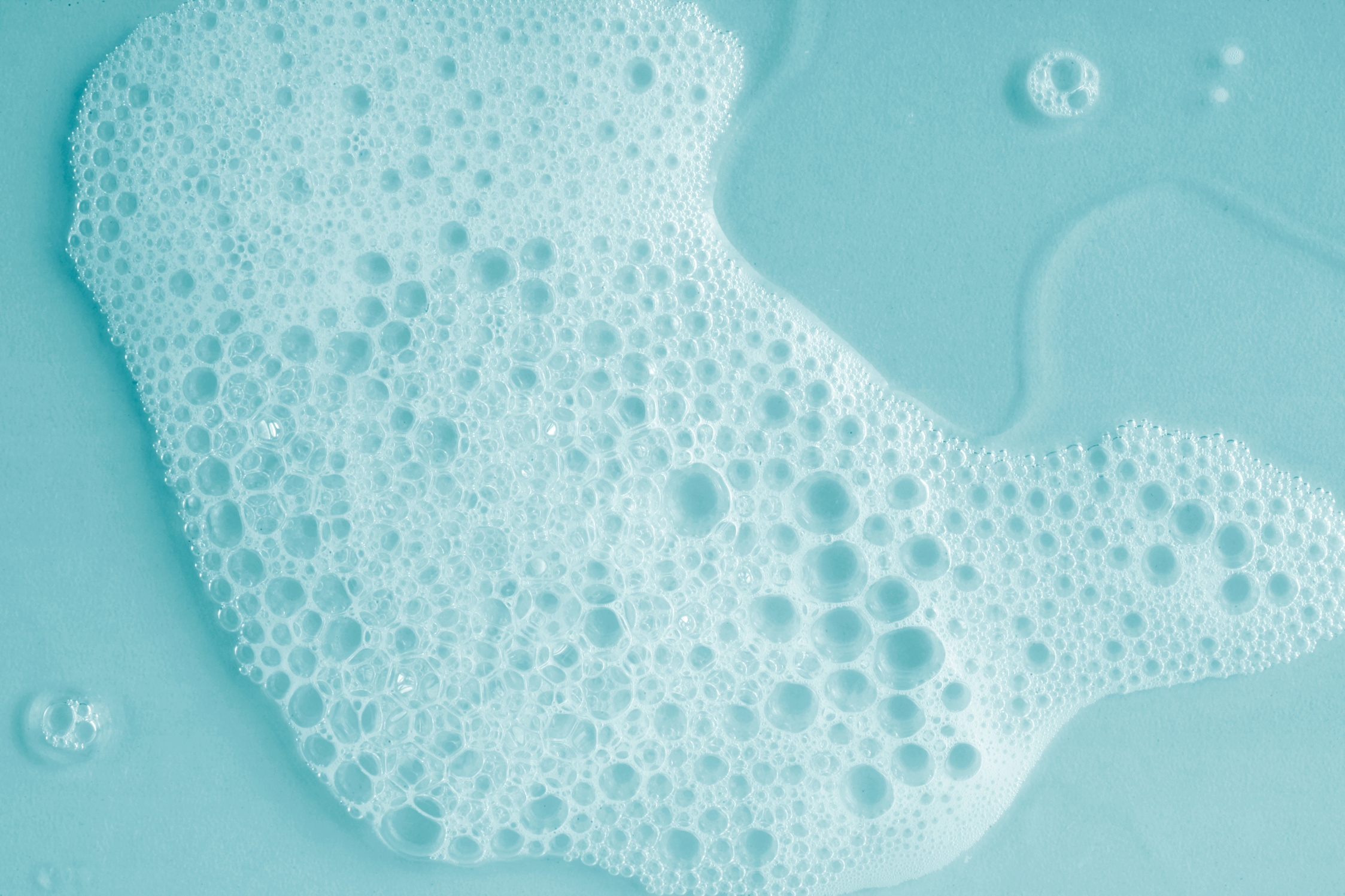 Foam soap shampoo, gel. Blue tone cosmetic background.
